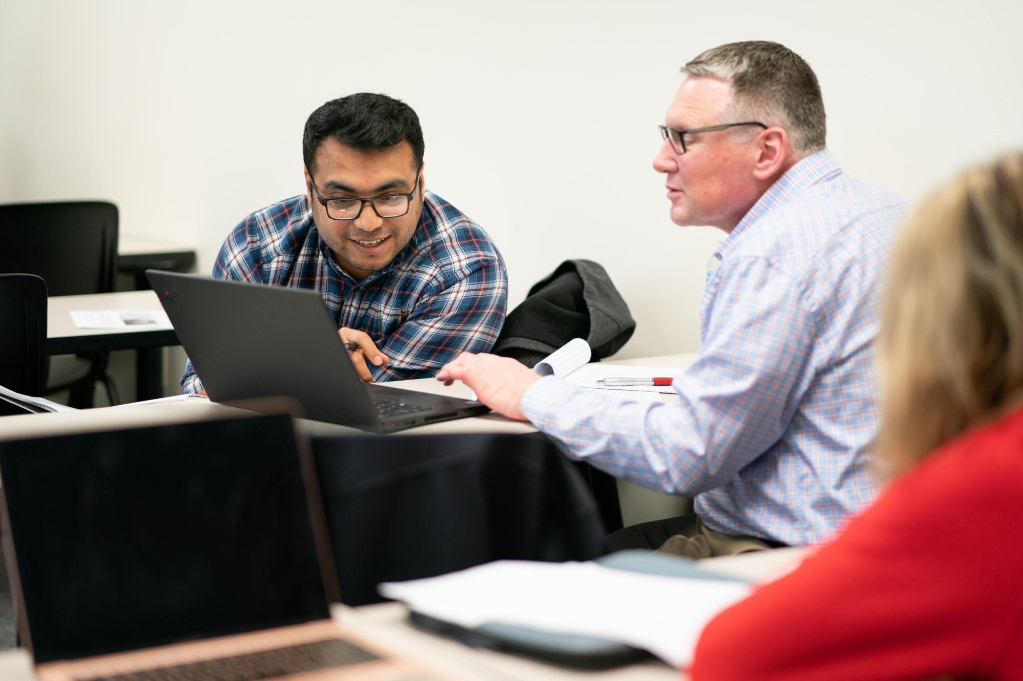 two adult learners looking at computers